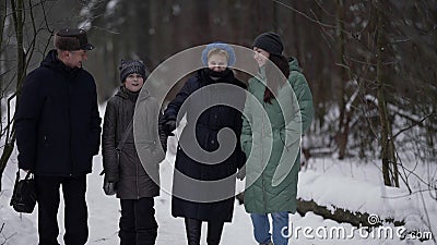 little girl and her mother and grandparents are walking in park at winter, happy family Stock Photo