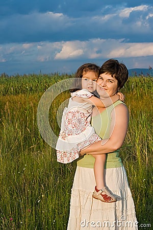 Little girl and her mother staying outside Stock Photo