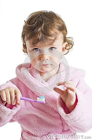 Little girl hesitating to brush her teeth Stock Photo