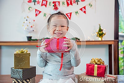 Little girl holding chirstmas day gift box and smiles Stock Photo