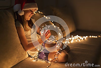 Little girl holding Christmas lights Stock Photo