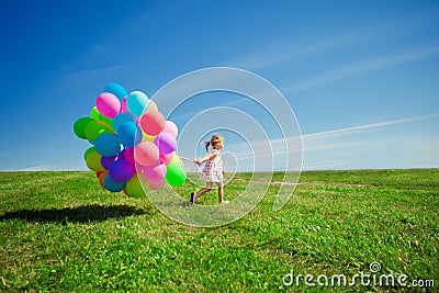 Little girl holding colorful balloons. Child playing on a green Stock Photo