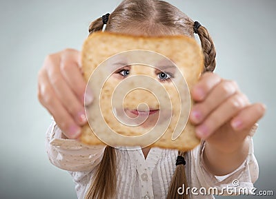 Little girl holding in front of his face, a happy slice of bread Stock Photo