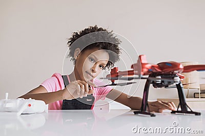 Little girl holding quadcopter. Child playing with drone at home. Stock Photo