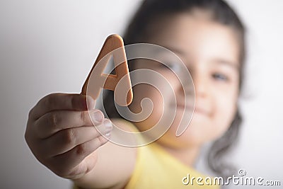 Little girl holding A spongy alphabet letter in right hand Stock Photo