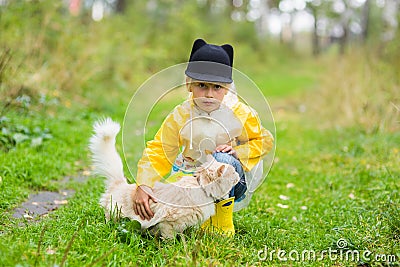 Little girl with homeless cat in autumn park. Concept of friendship Stock Photo