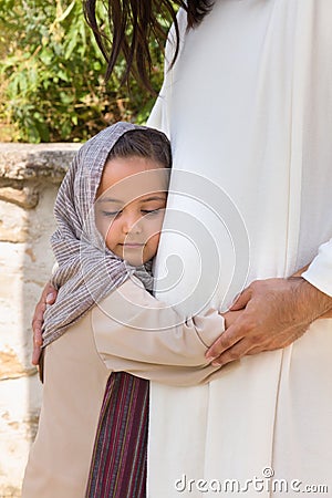 Little girl hugging Jesus Stock Photo