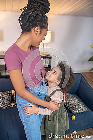 Little girl hugging looking at smiling mom Stock Photo