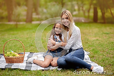 Little Girl Hugging With Mother Bonding On Picnic Outside Stock Photo