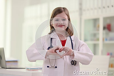 Little girl imitates role of doctor showing heart sign Stock Photo