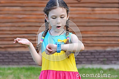 Little girl with indignation and surprise talking on the street on a smart watch..Safety concept Stock Photo