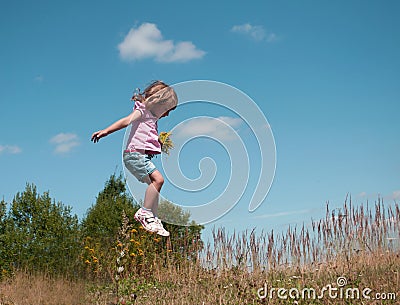 A little girl jumping against the blue sky background Stock Photo