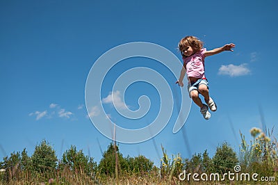 A little girl jumping against the blue sky background Stock Photo