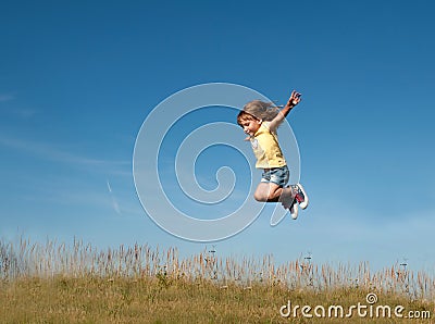 A little girl jumping against the blue sky background Stock Photo