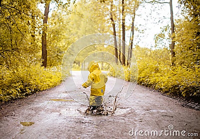 Little girl jumping fun in a dirty puddle Stock Photo