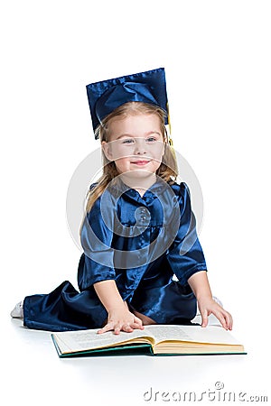 Little girl kid in academician clothes reading book Stock Photo