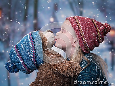 A little girl kisses a Teddy bear. Stock Photo