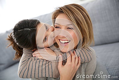 Little girl kissing her mother in cheek Stock Photo
