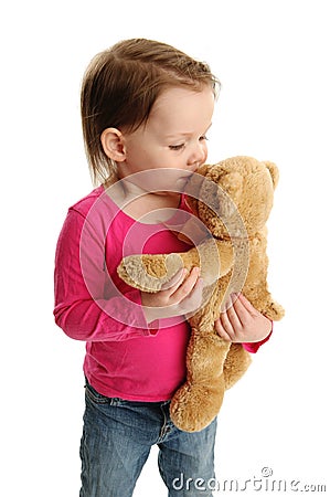 Little girl kissing teddy bear Stock Photo