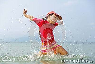 Little girl laughing and crying in the spray of waves at sea Stock Photo