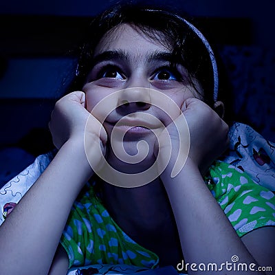 Little girl laying in bed daydreaming, Stock Photo