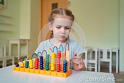 Little girl learning to add and subtract accounts. Stock Photo