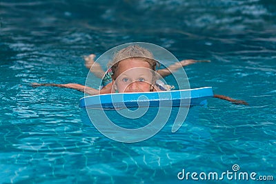 Little girl learning to swim in big sport pool. Swimming school for small children. Healthy kid enjoying active lifestyle. Prescho Stock Photo