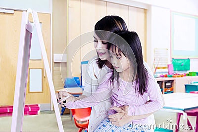Little girl learning a write with her teacher Stock Photo