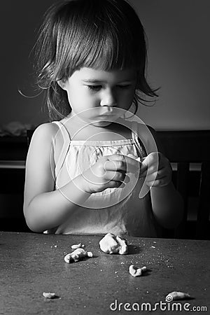Little girl learns to make dough Stock Photo