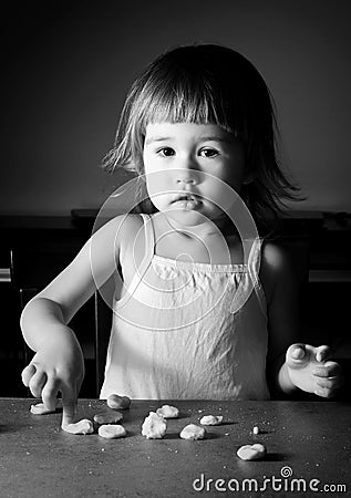 Little girl learns to make dough Stock Photo