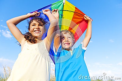 Little Girl And Little Boy Playing Kite Together Stock Photo