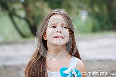 Little girl with long hair portrait, emotionally crying and upset, natural lighting outside Stock Photo
