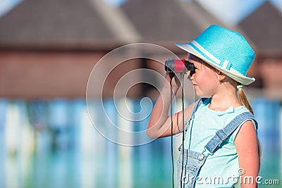 Little girl looking through binoculars in sunny Stock Photo