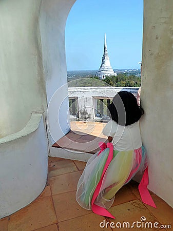 Little girl looking out from quiet top tower to big pagoda on Phra Nakhon Khiri Royal Palace, Phetchaburi, Thailand Editorial Stock Photo