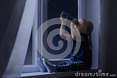 Little girl looking at the sky full of stars Stock Photo