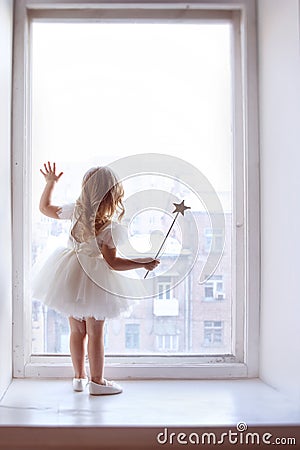 Little girl looks out window waits for Santa Claus Stock Photo