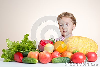 Little girl and a lot of fruit and vegetables. Stock Photo