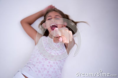 Little Girl lying with finger pointing and laughing Stock Photo
