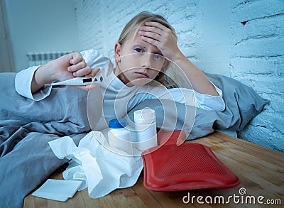 Little girl lying sick in bed feeling sick with high fever and headache having a cold flu Stock Photo