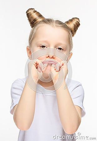 Little girl made a sad grimace on a white background. The concept of manifestation of discontent or whim Stock Photo