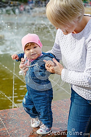 Little girl makes the first steps with his mother Stock Photo