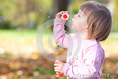 Little girl making bubble blower on the autumn forest Stock Photo
