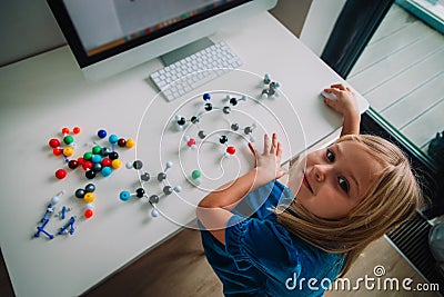 Little girl making model of a molecule with computer program, learning chemistry, online learning and STEM Stock Photo
