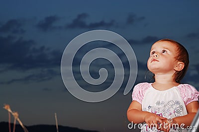 Little girl on meadow before sunset Stock Photo