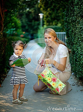 Little girl with mom holding present Stock Photo