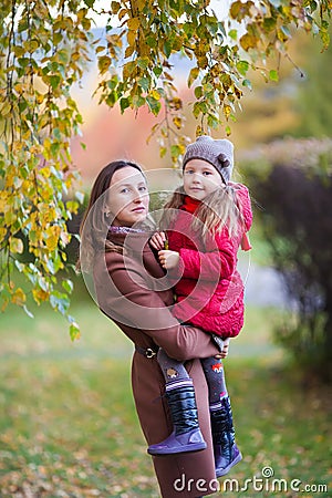 Little girl and mother in the autumn park Stock Photo