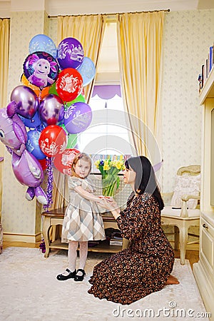 little girl and mum at home with balloons. Inflatable hero of Russian cartoon Editorial Stock Photo