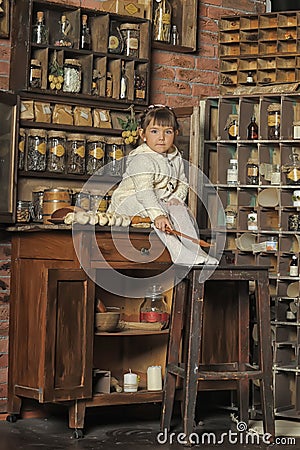 Little girl on the old kitchen Stock Photo