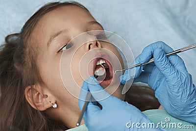 Little girl with open mouth sitting in the dentist`s chair Stock Photo