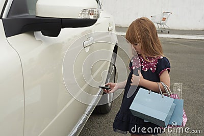 Little girl opens a car Stock Photo